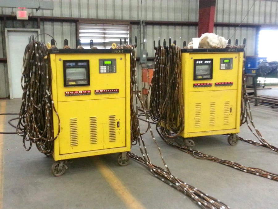 Two mobile heat treatment units rigged on site, heating cables and thermocouple leads run out to the work.