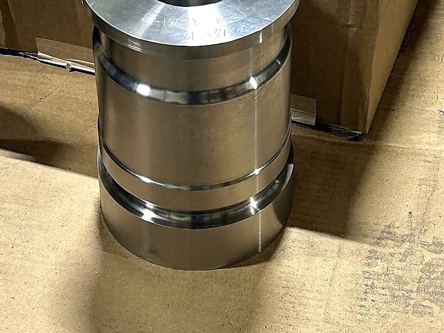 A turned cylindrical component with stepped diameters, finished and set down on the bench.