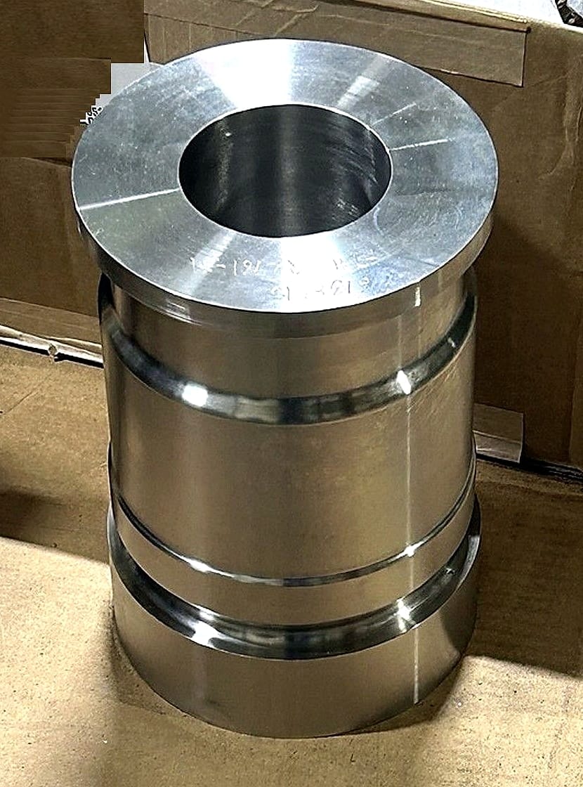 A finished turned component shown whole: flanged top, machined bore and two ground grooves down the body.