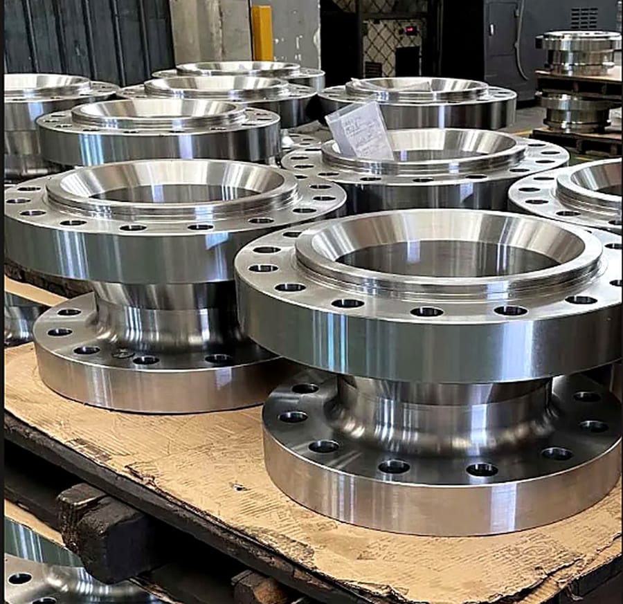 A batch of finished machined flanges stacked on a pallet.