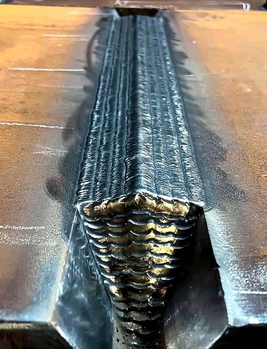 A multi-pass weld run along a groove joint, each pass visible in sequence.