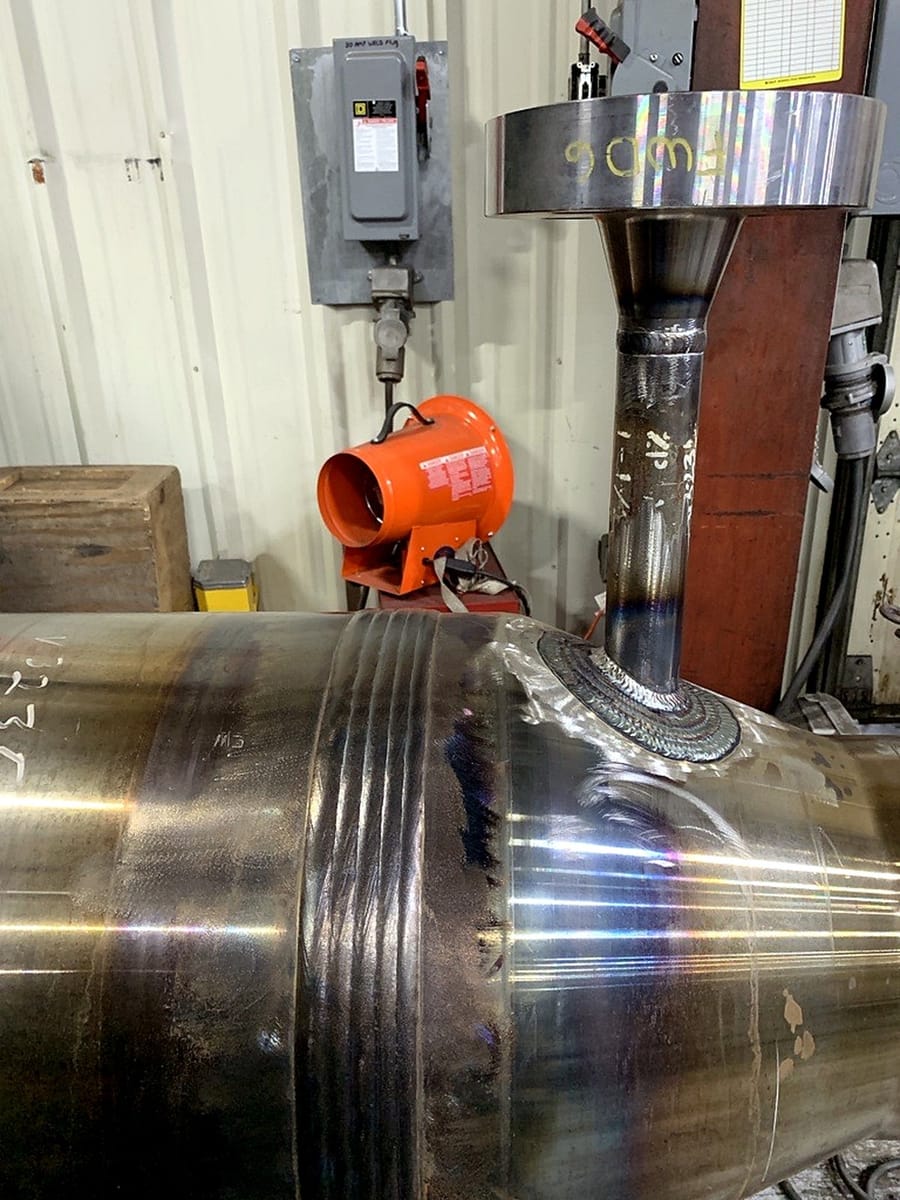 A nozzle welded into a cylindrical shell, the finished fillet visible at the base.