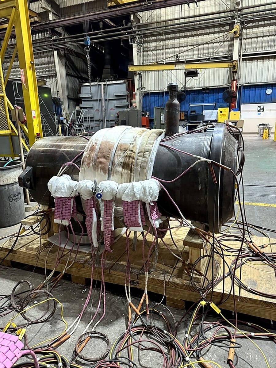 A cylindrical assembly wrapped with heating elements and insulation, thermocouples attached.