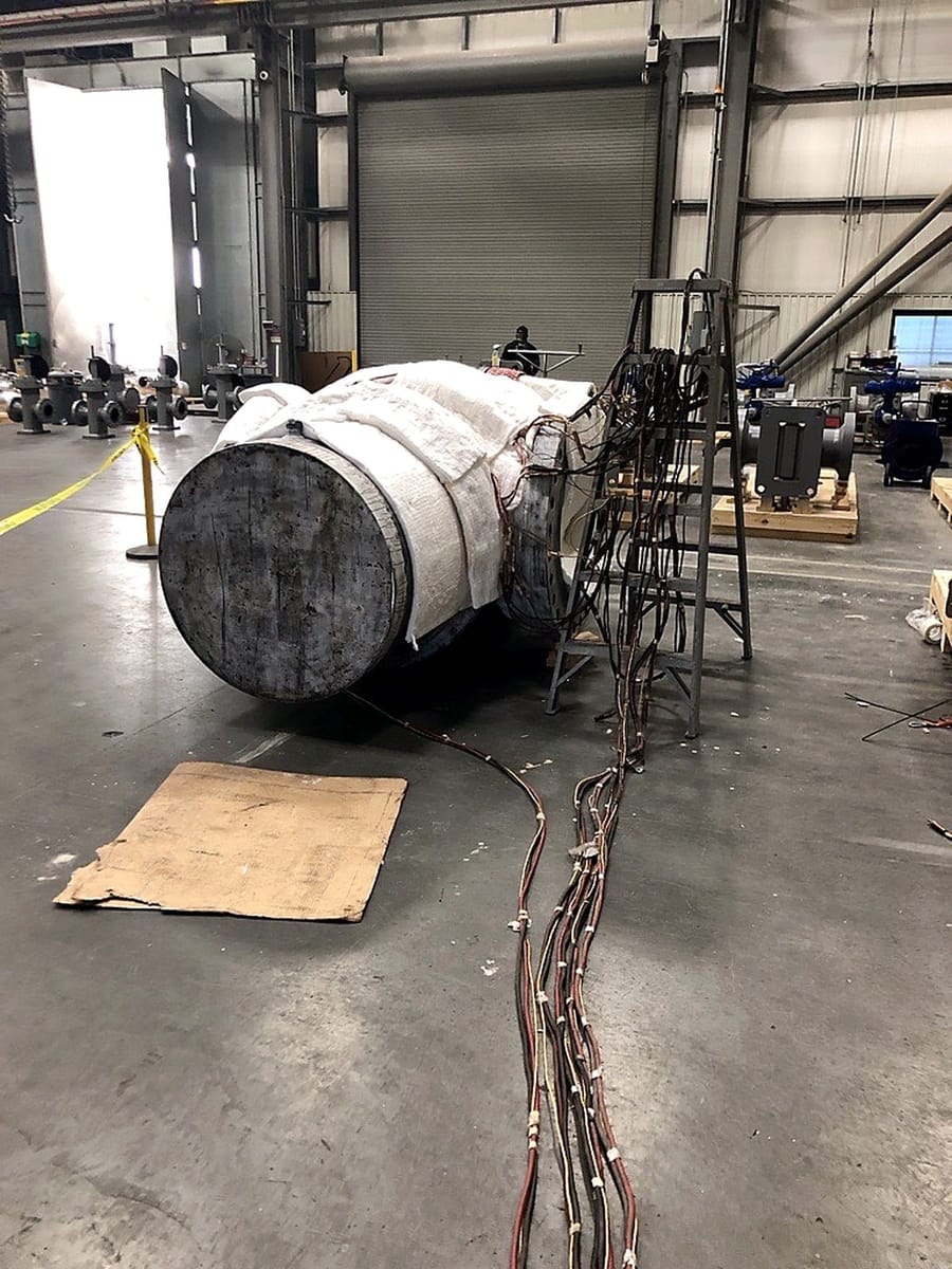 An insulated assembly on the shop floor with thermocouple leads running back to the console.