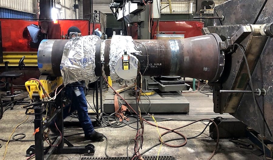 A pipe assembly wrapped for heat treatment on the welding rig.