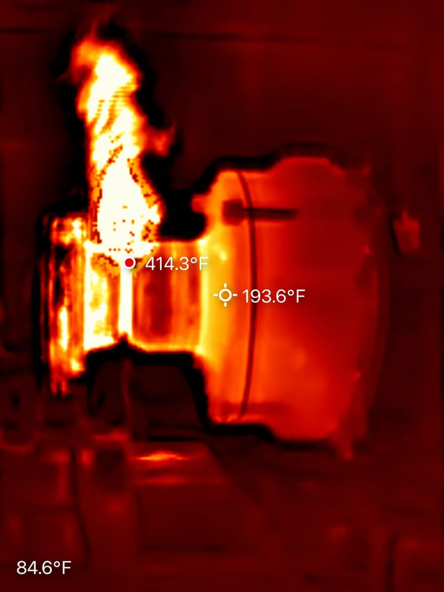 A thermal camera image of a flanged component under heat, with spot readings of 414 and 194 degrees Fahrenheit.